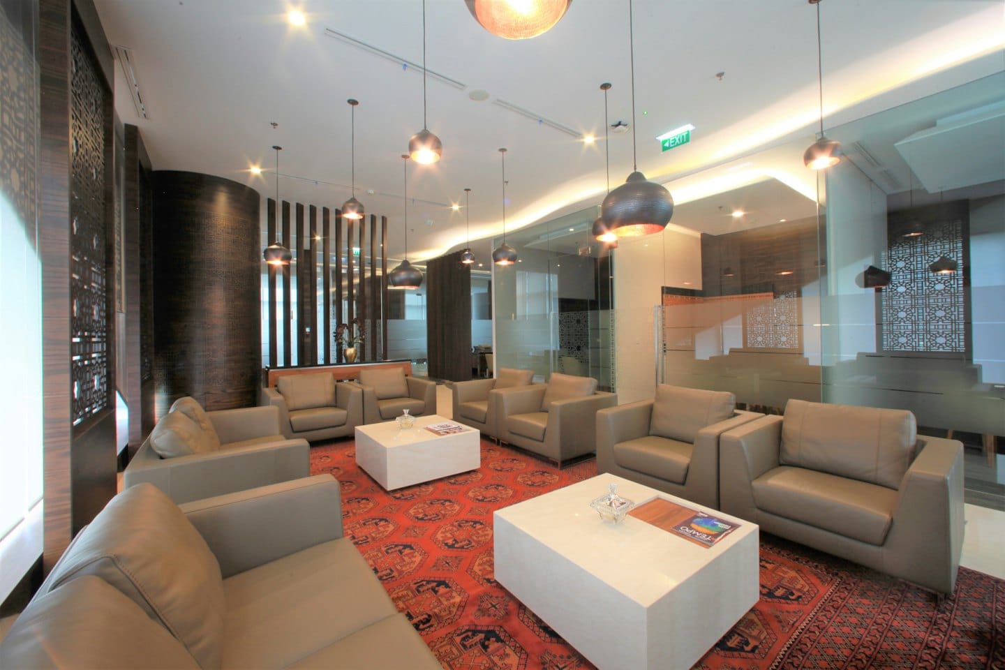 Leather sofas and armchairs sit on a large patterned rug.