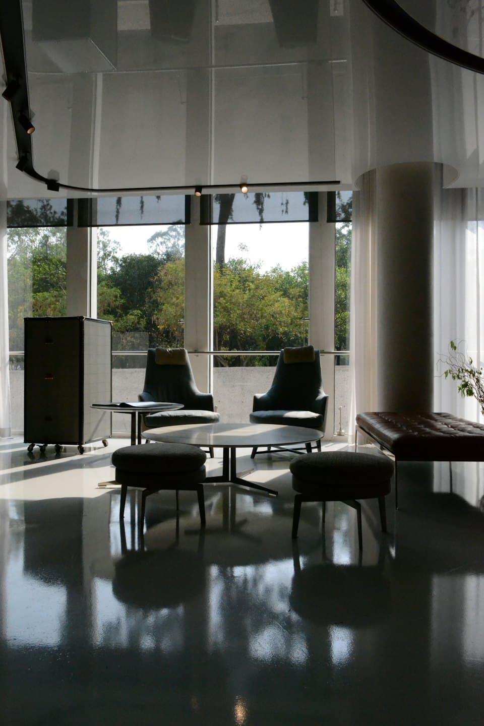Modern lounge with contemporary furniture and large windows.