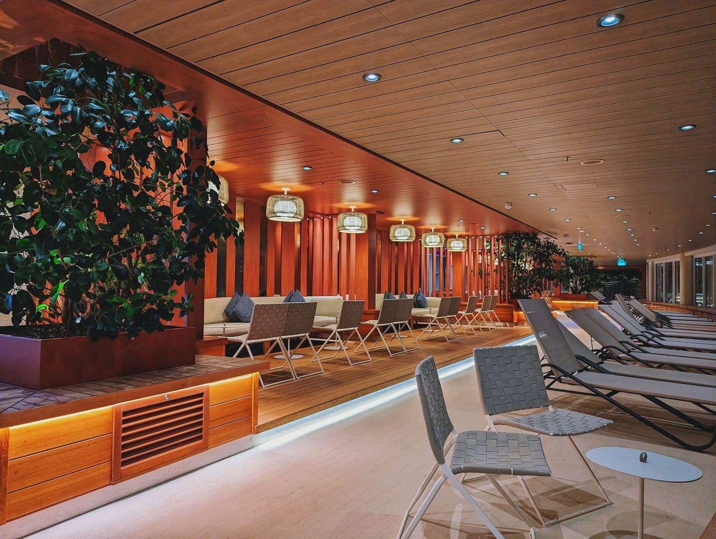 Luxurious lounge with green plants and beige seating.